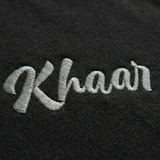 Black 1947 Crewneck front — stitched Khaar Studios branding at chest