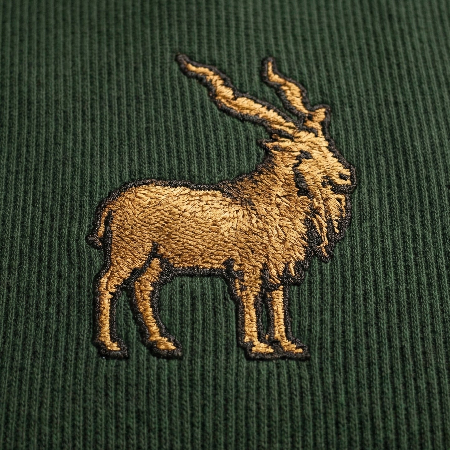 Khaar Markhor Knit Sweater in Forest Green – Green logo closeup