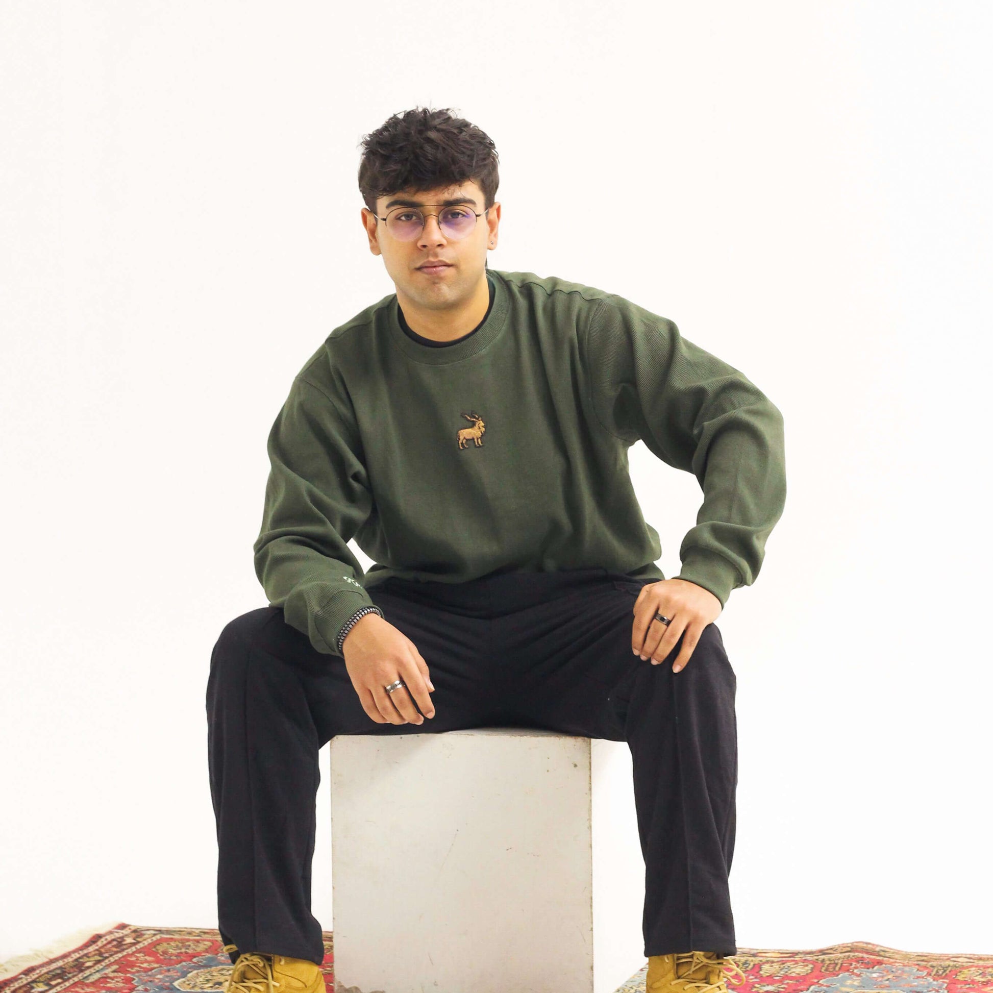 Khaar Markhor Knit Sweater in Forest Green – Male model sitting